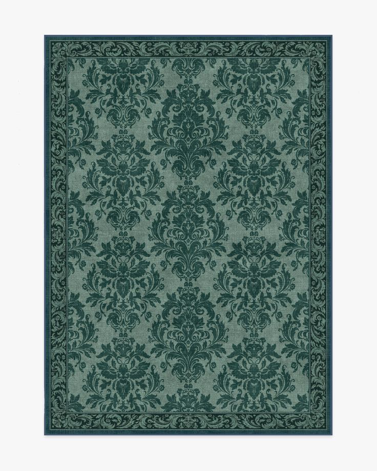 a green rug with an ornate design on the front and back side, in dark blue