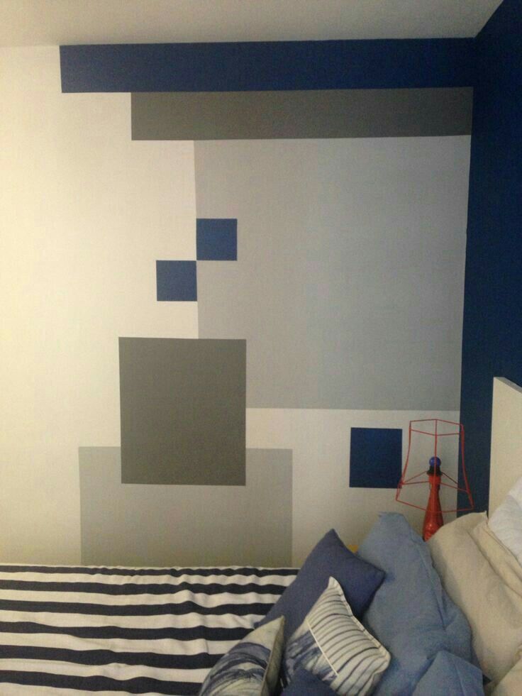 a bed room with a neatly made bed and blue wall paint on the walls behind it