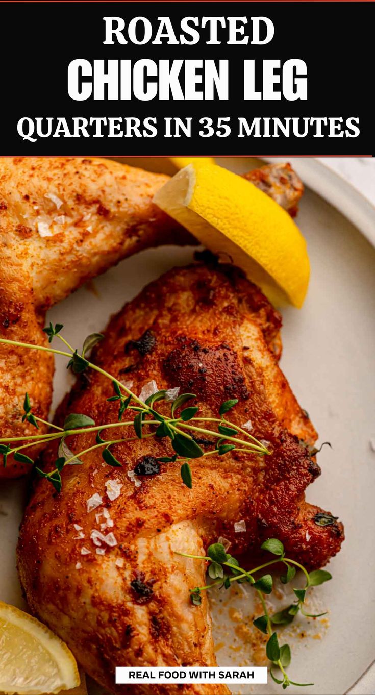 roasted chicken leg quarters on a plate with lemon wedges and garnishes