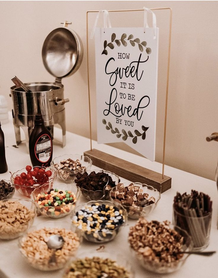 a table topped with lots of different types of snacks and confection items next to a sign that says how sweet it is