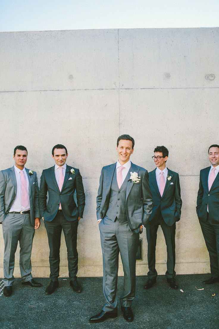 a group of men standing next to each other wearing suits and ties on their wedding day