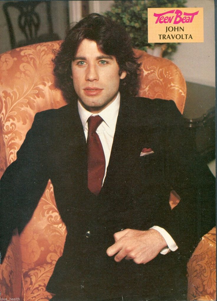 a man sitting in a chair wearing a suit and tie