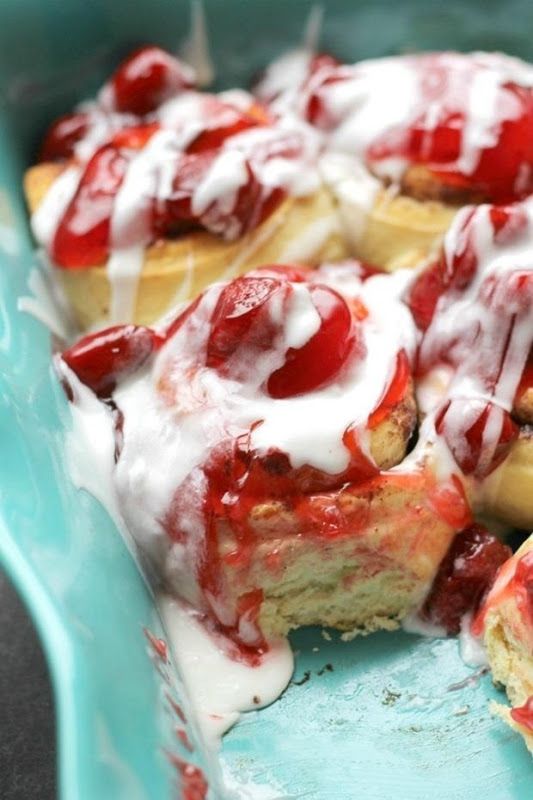 strawberry shortcakes with icing and strawberries on top in a blue dish