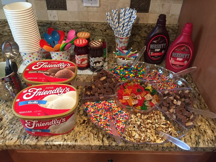 the ingredients for a candy bar are displayed on the counter top, including milk, cereals, and candies