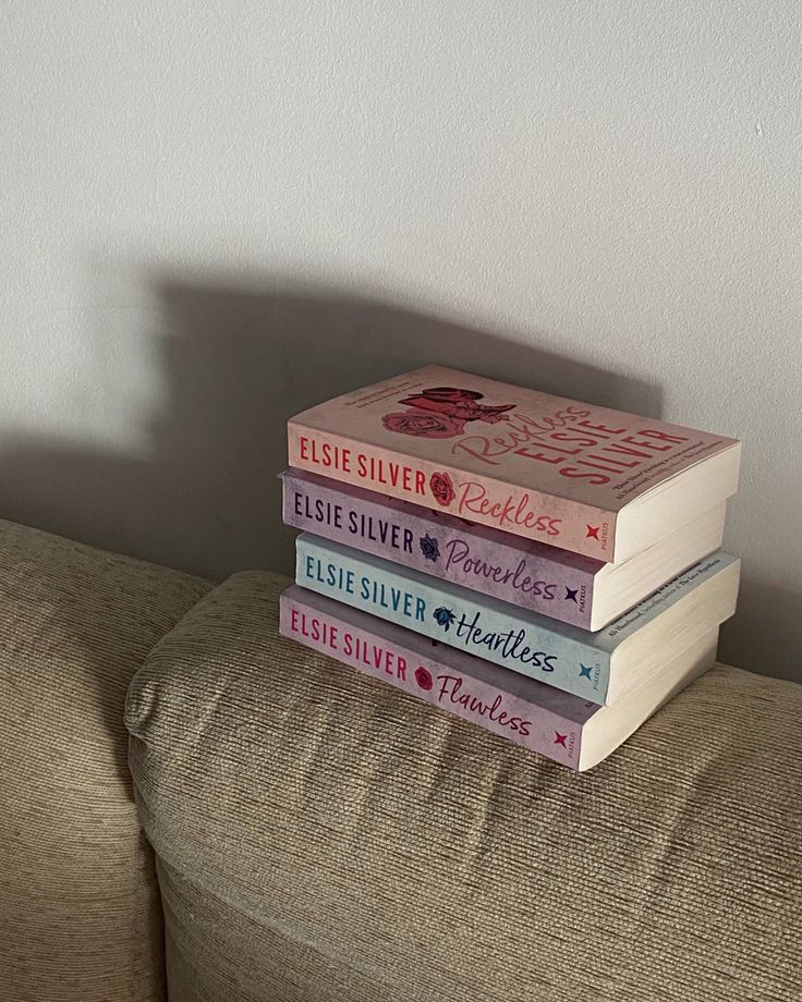 a stack of books sitting on top of a couch