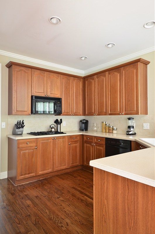 a kitchen with wooden cabinets and white counter tops