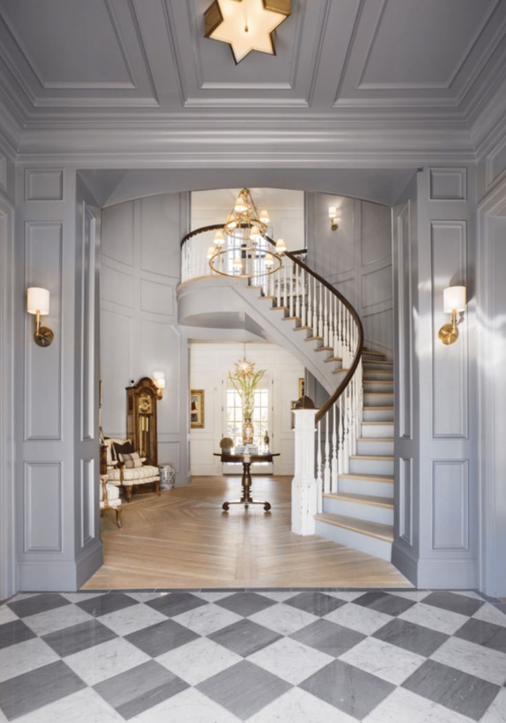 a large foyer with stairs, chandelier and checkerboard flooring is shown