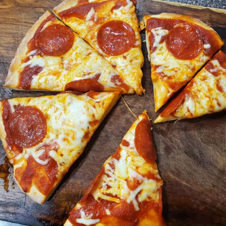 four slices of pepperoni pizza on a cutting board