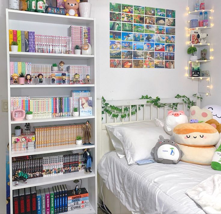 a white bed topped with lots of books next to a book shelf filled with stuffed animals