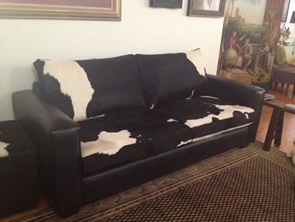 a black and white couch sitting on top of a wooden floor