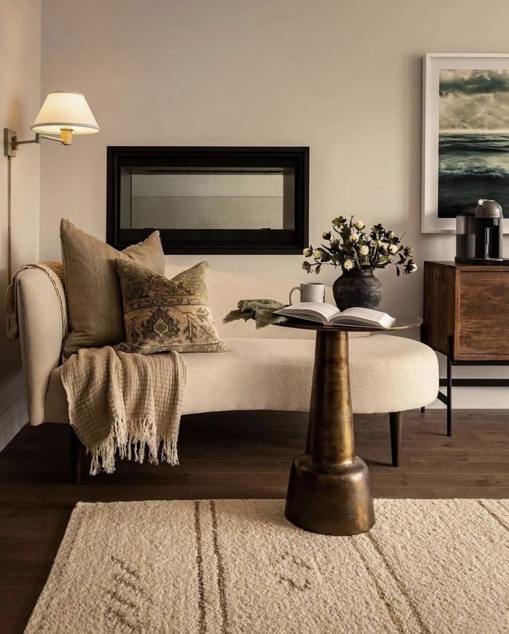 a living room with a couch, table and pictures on the wall in it's corner