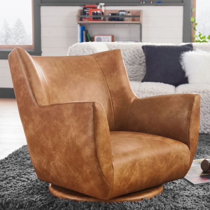 a brown leather chair sitting on top of a rug