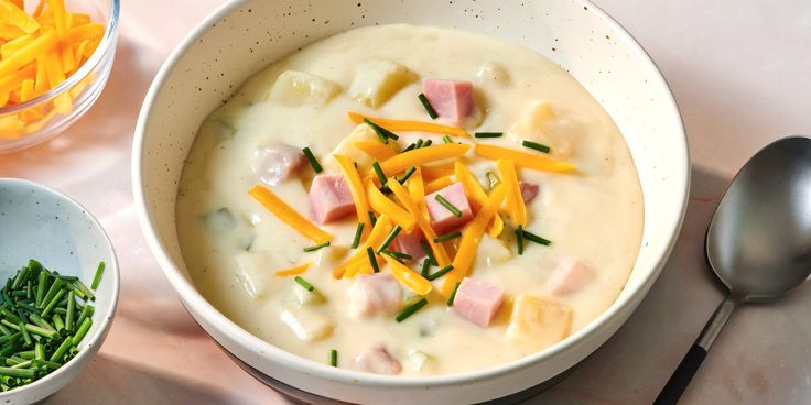 a bowl of soup with ham and cheese on top