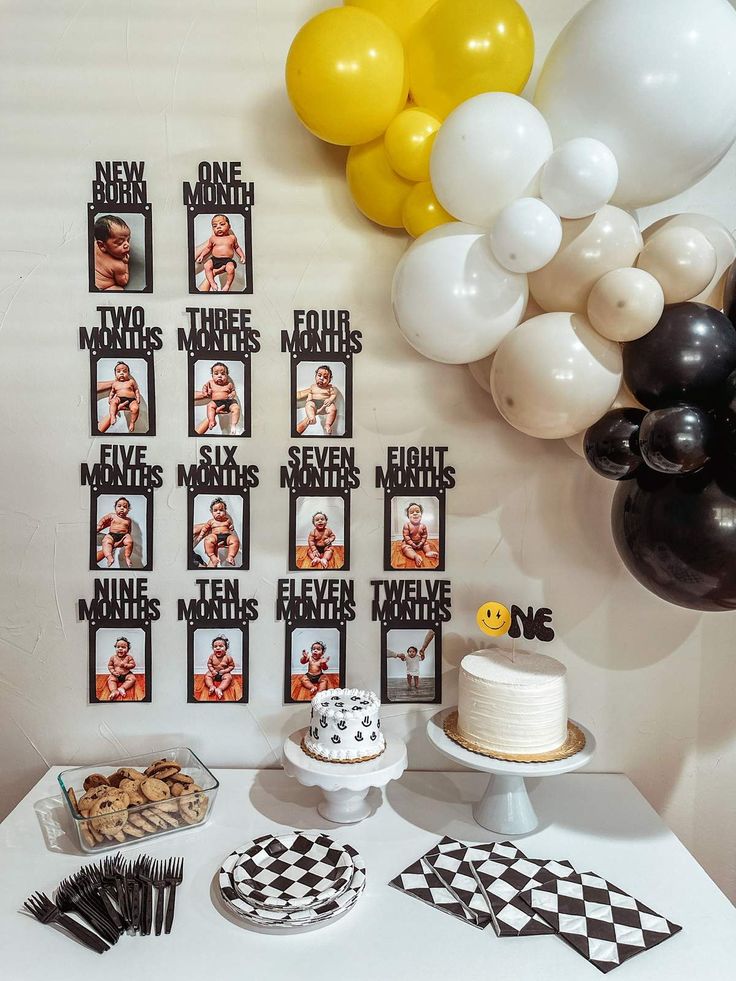 a table topped with cake and balloons next to pictures on the wall above it that say two different men