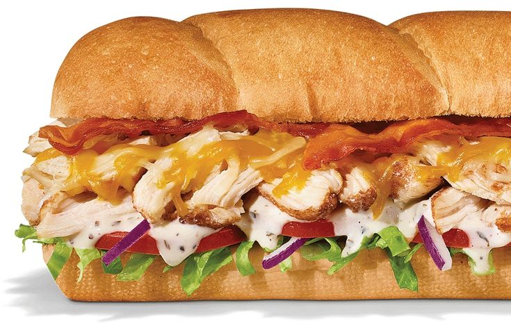 two sub sandwiches with chicken, cheese and lettuce on them are sitting next to each other