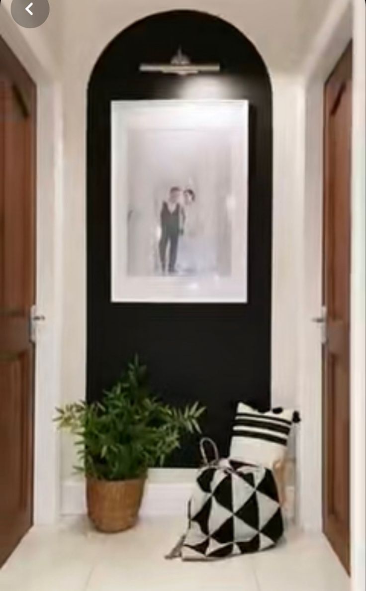 a black and white photo hanging on the wall next to a plant in a pot