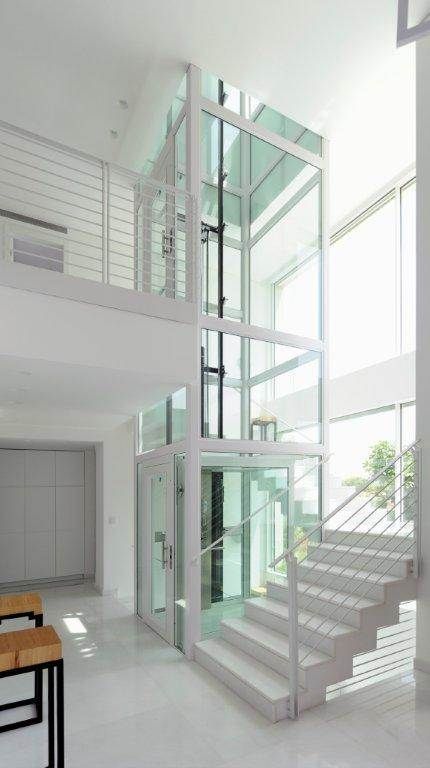 an empty room with white walls and stairs leading to the second floor, which has glass balconies on both sides