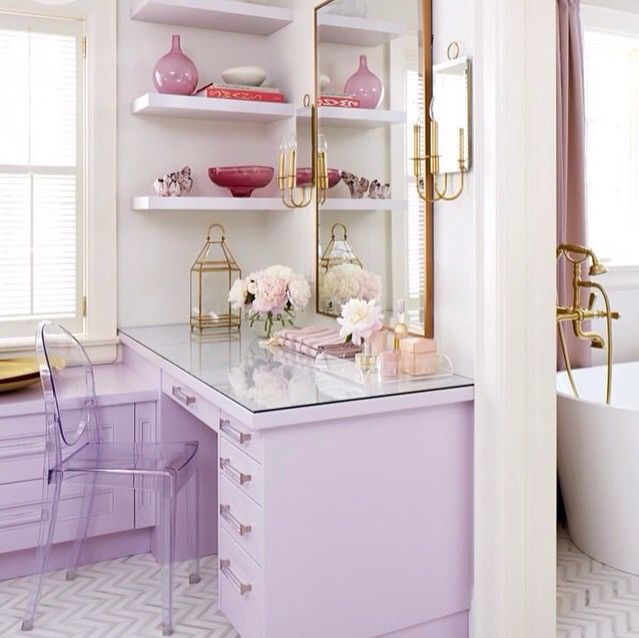 a bathroom with pink and gold accessories on the shelves