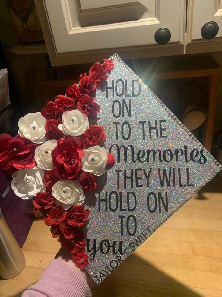 a decorated graduation cap with flowers on the front and writing on the back that says hold on to the memories they will hold on to you