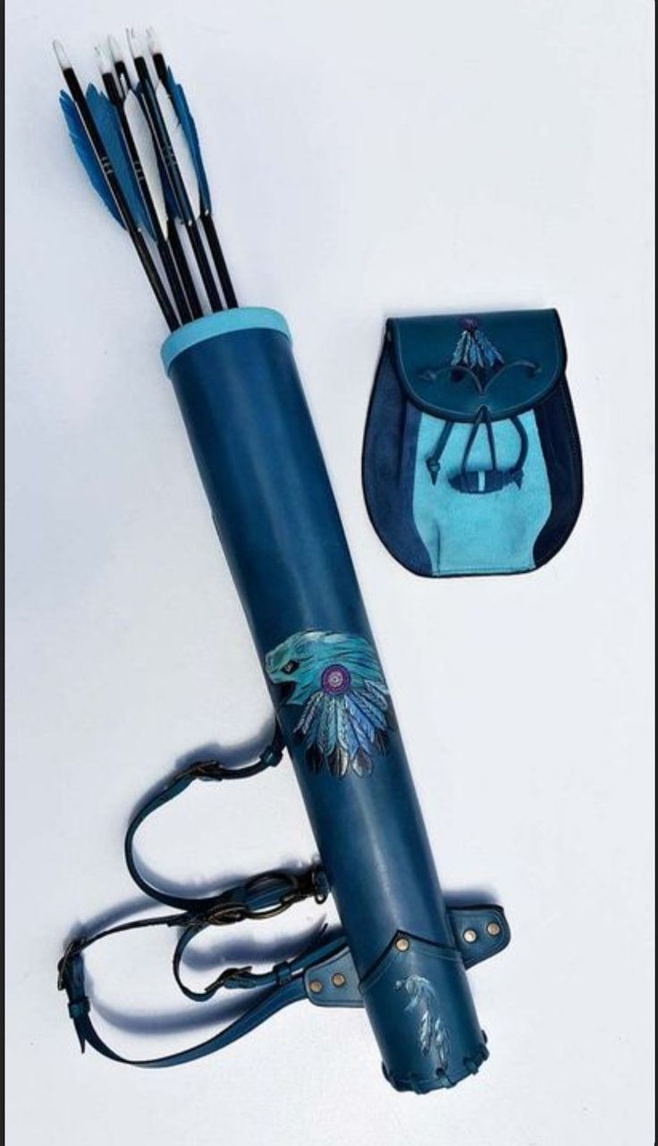 a blue umbrella with arrows in it next to a purse and some other things on the table