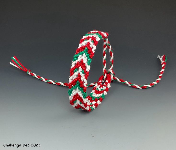 two red, white and green bracelets sitting next to each other on a gray surface