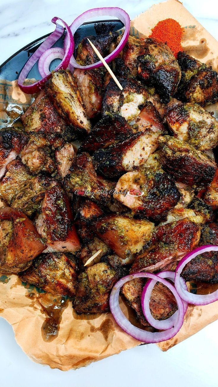 meat and onion skewers on a plate with red onions