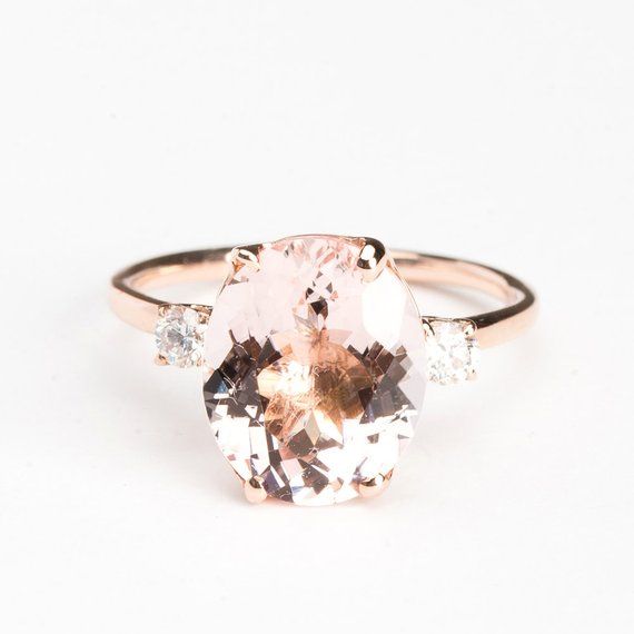 an oval morganite and diamond ring on a white background