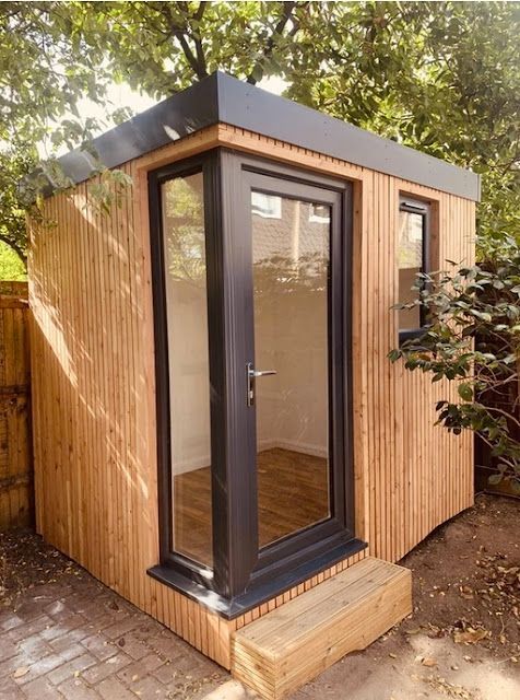 a small wooden shed with its doors open