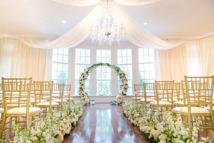 the ceremony room is decorated with white flowers and greenery