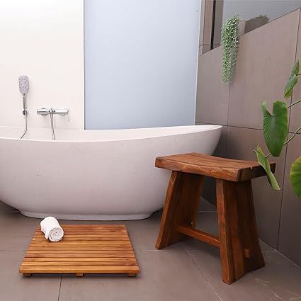 a white bath tub sitting next to a wooden stool