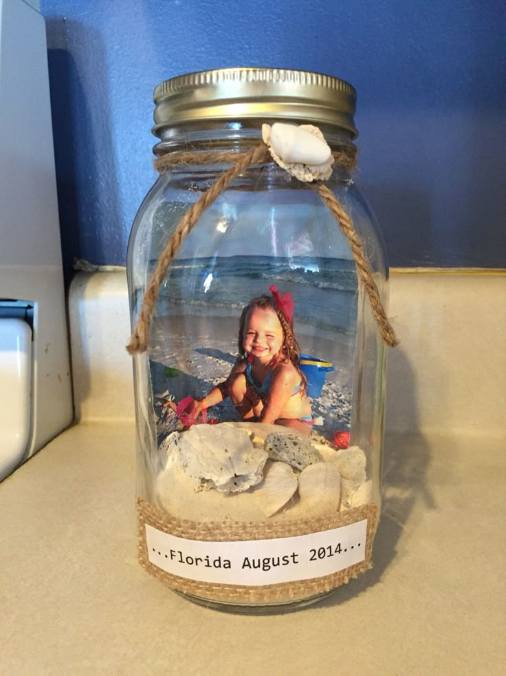 a glass jar filled with sand and shells