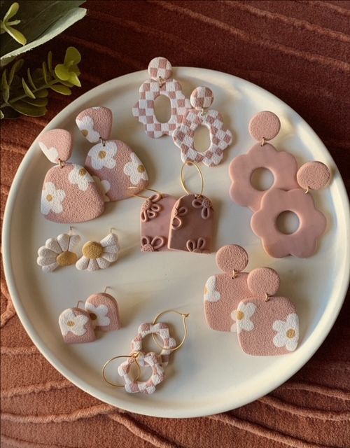 a white plate topped with lots of pink and white decorated items on top of a wooden table