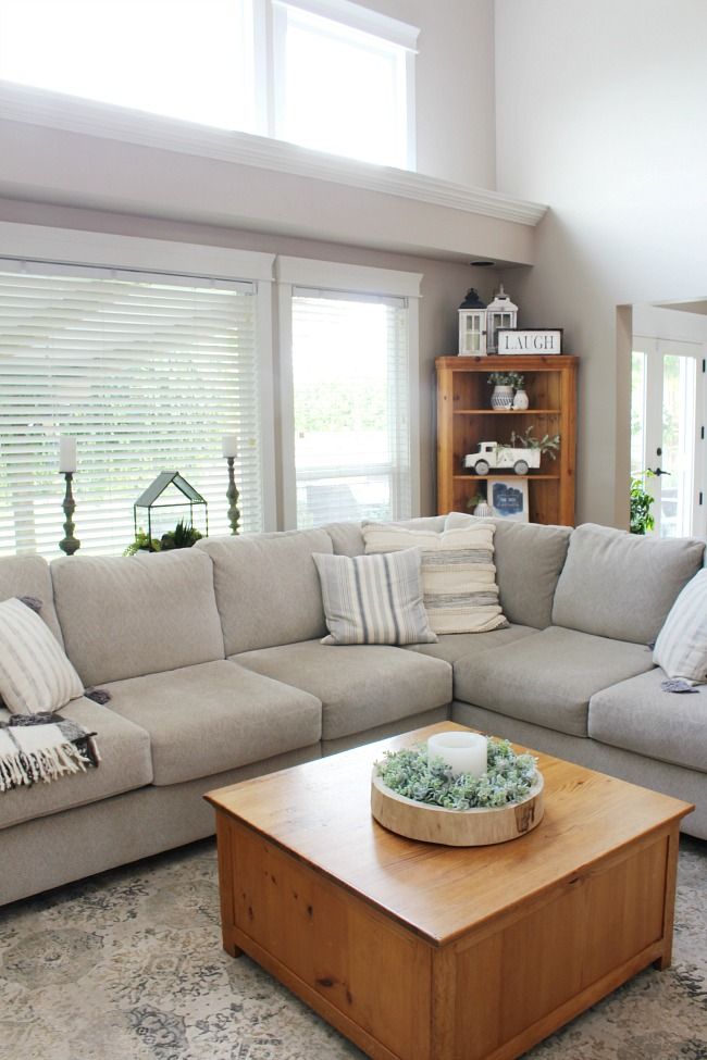 a living room filled with furniture and a wooden coffee table in front of a window