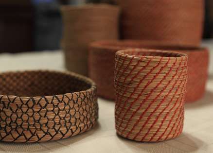 three different types of baskets sitting on a table next to some potted planters