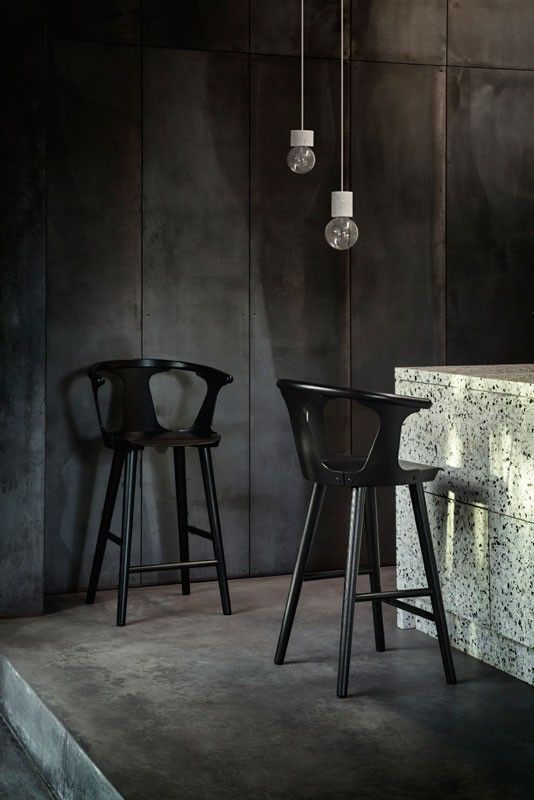 two black chairs sitting next to each other in front of a counter with lights on it