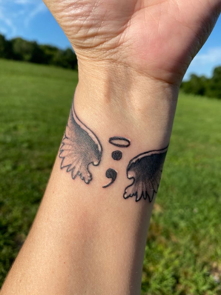 a hand with a tattoo on it that has an eagle and heart in the middle