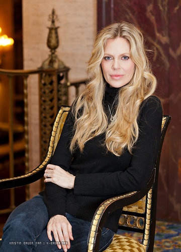 a woman sitting in a chair with her arms crossed and looking off to the side