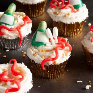 cupcakes decorated with white frosting, red and green icing and decorations