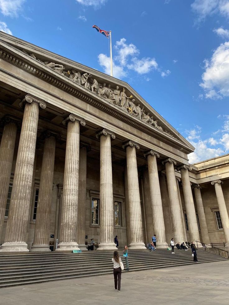 a person standing in front of a large building with columns