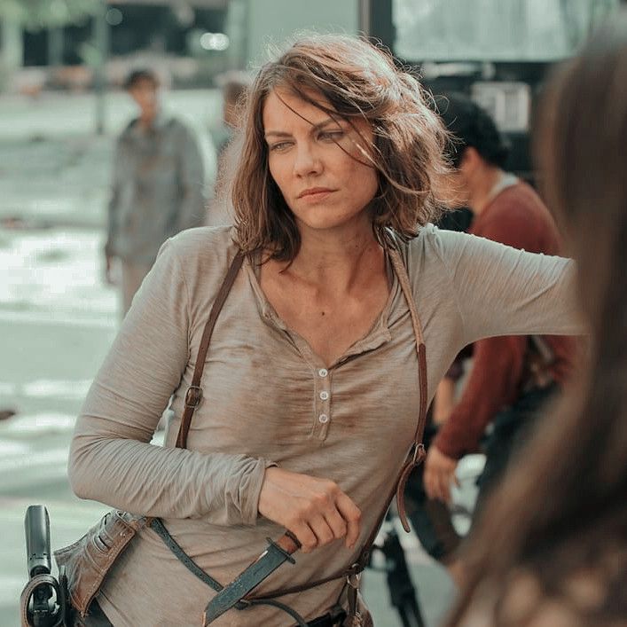 a woman holding a camera and looking at another woman with her hand on her hip