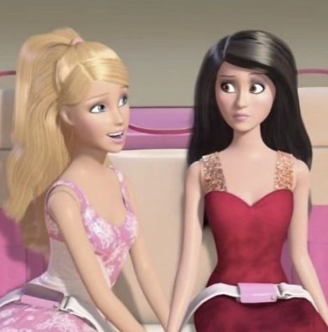 two barbie dolls sitting next to each other on a bed