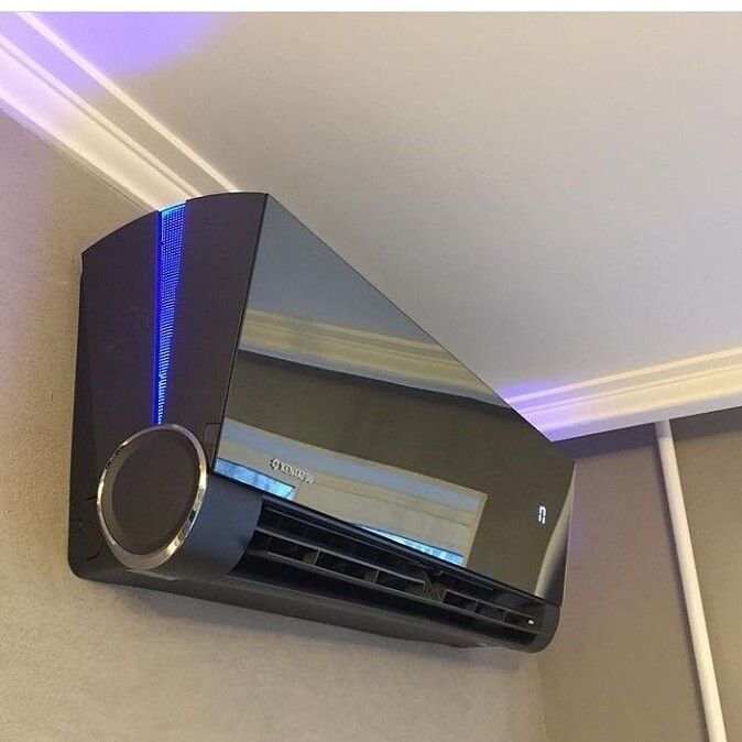 an air conditioner mounted to the side of a wall with blue lights on it