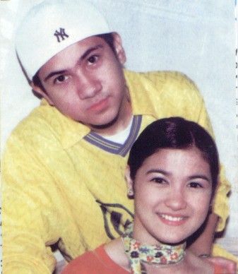 an old photo of two people posing for a picture with one person wearing a hat