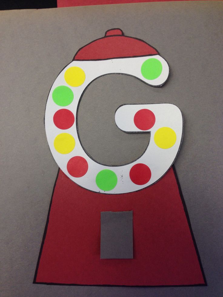 the letter g is made out of paper with dots on it and a red stand