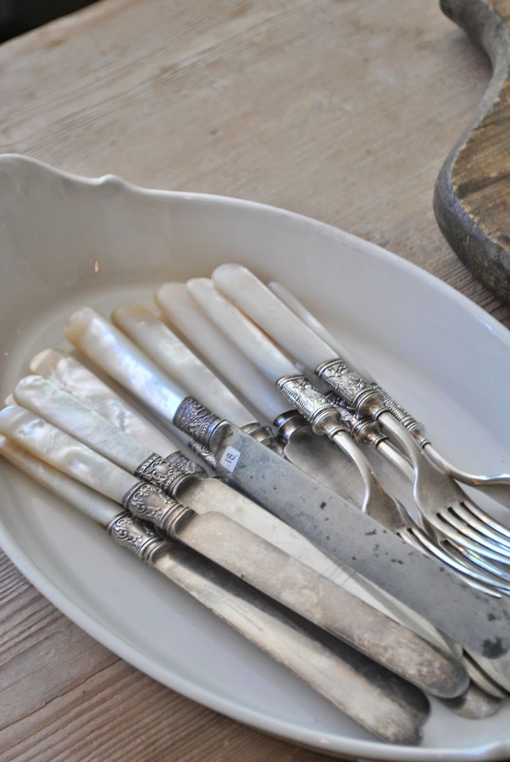 a white plate topped with silverware on top of a wooden table