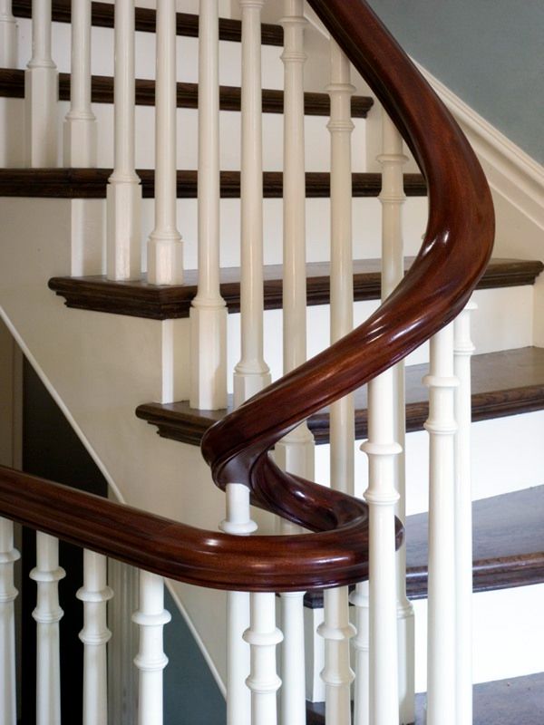 a white staircase with wooden handrails in a house