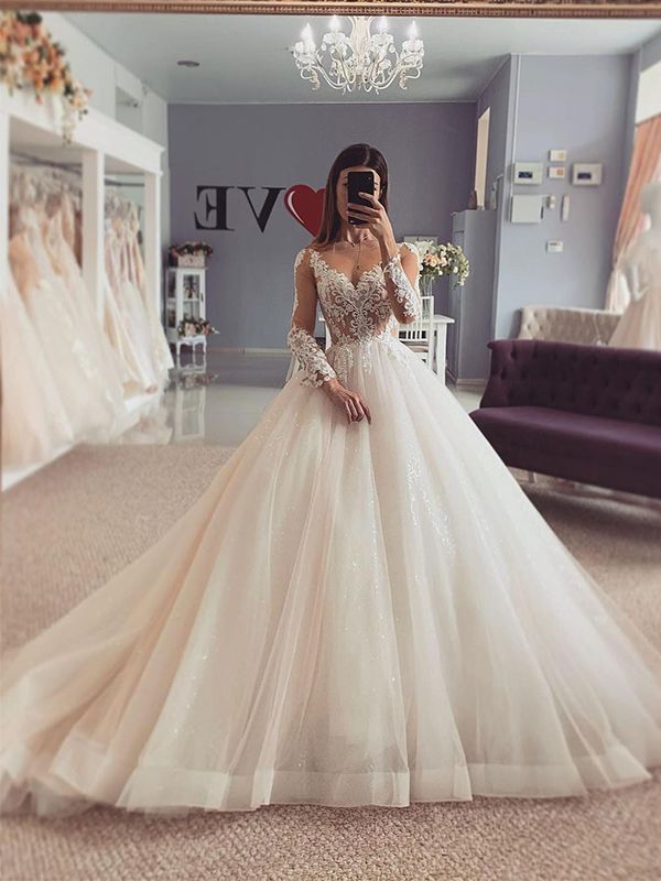 a woman in a wedding dress taking a selfie with her cell phone while standing in front of a mirror