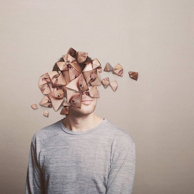 a man standing in front of a wall with many pieces of wood on top of his head