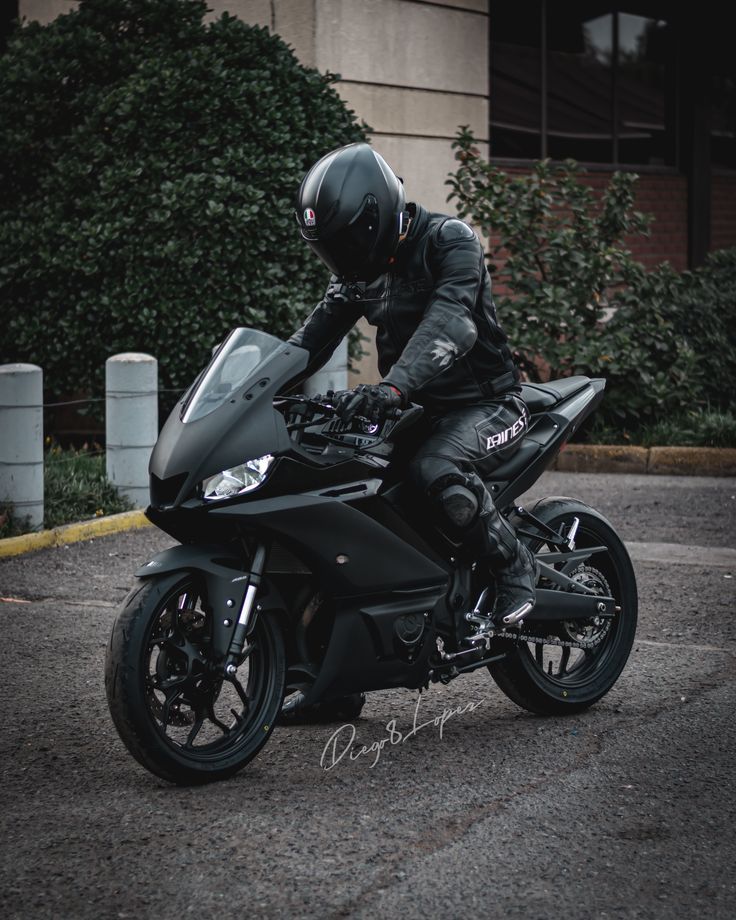 a man riding on the back of a black motorcycle