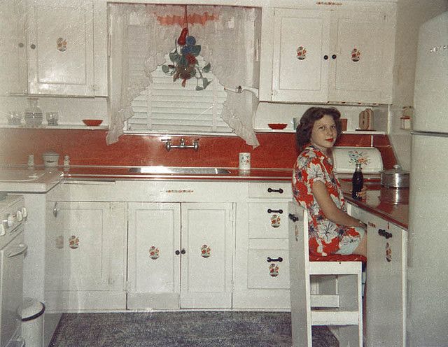 a woman sitting on a stool in a kitchen